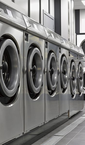 Row of industrial washing machines in a public laundromat
