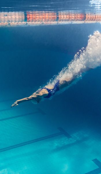 underwater picture of young female swimmer exercising in swimming pool